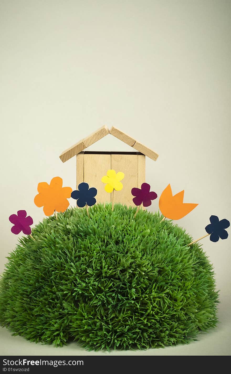 Wooden model of house on green grass