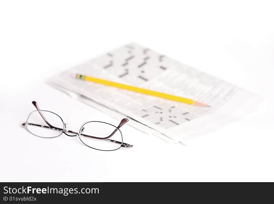 This is a pair of reading glass on a light surface with a blurry crossword puzzle and bright pencil in the background. As we get older, our eyes get worse and many people need reading glasses. This is a pair of reading glass on a light surface with a blurry crossword puzzle and bright pencil in the background. As we get older, our eyes get worse and many people need reading glasses