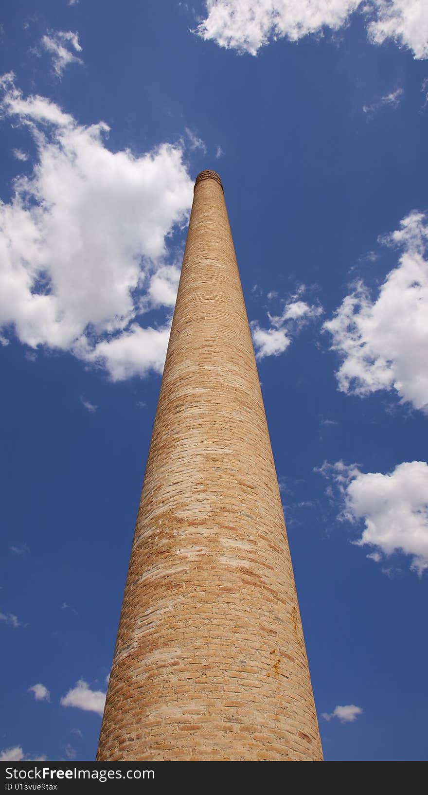 Old brick chimney against the blue sky