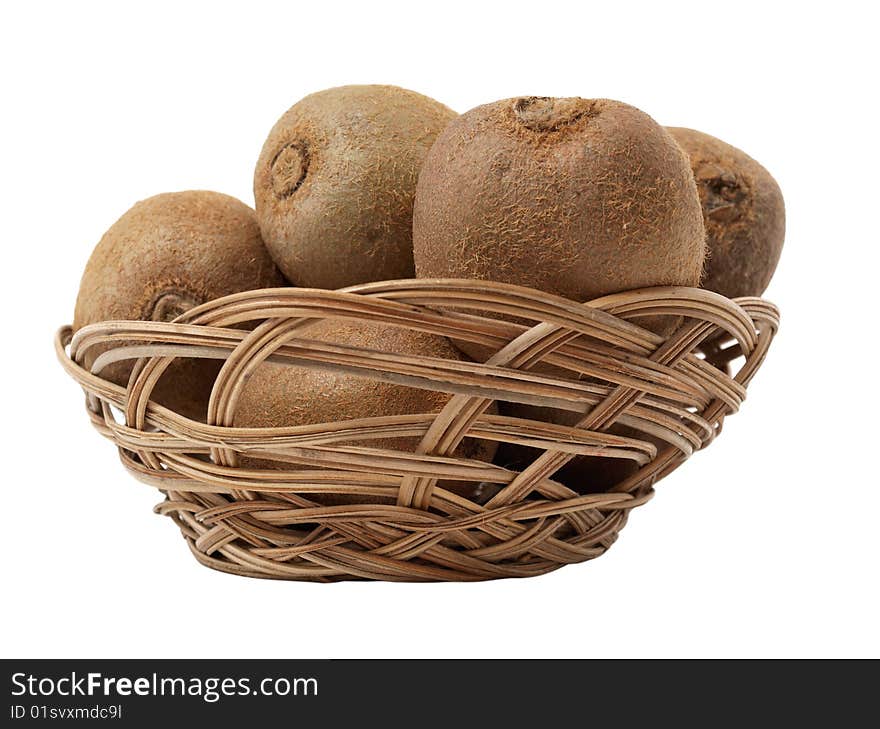 Color photo of kiwi fruit in a wicker basket against the backdrop of bananas and oranges