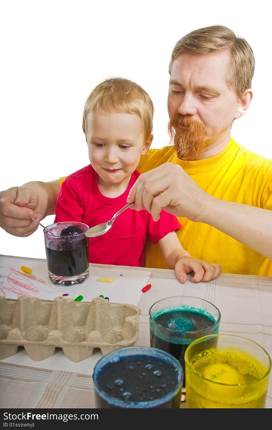 The man and the boy take out an Easter egg from a glass with a paint. The man and the boy take out an Easter egg from a glass with a paint