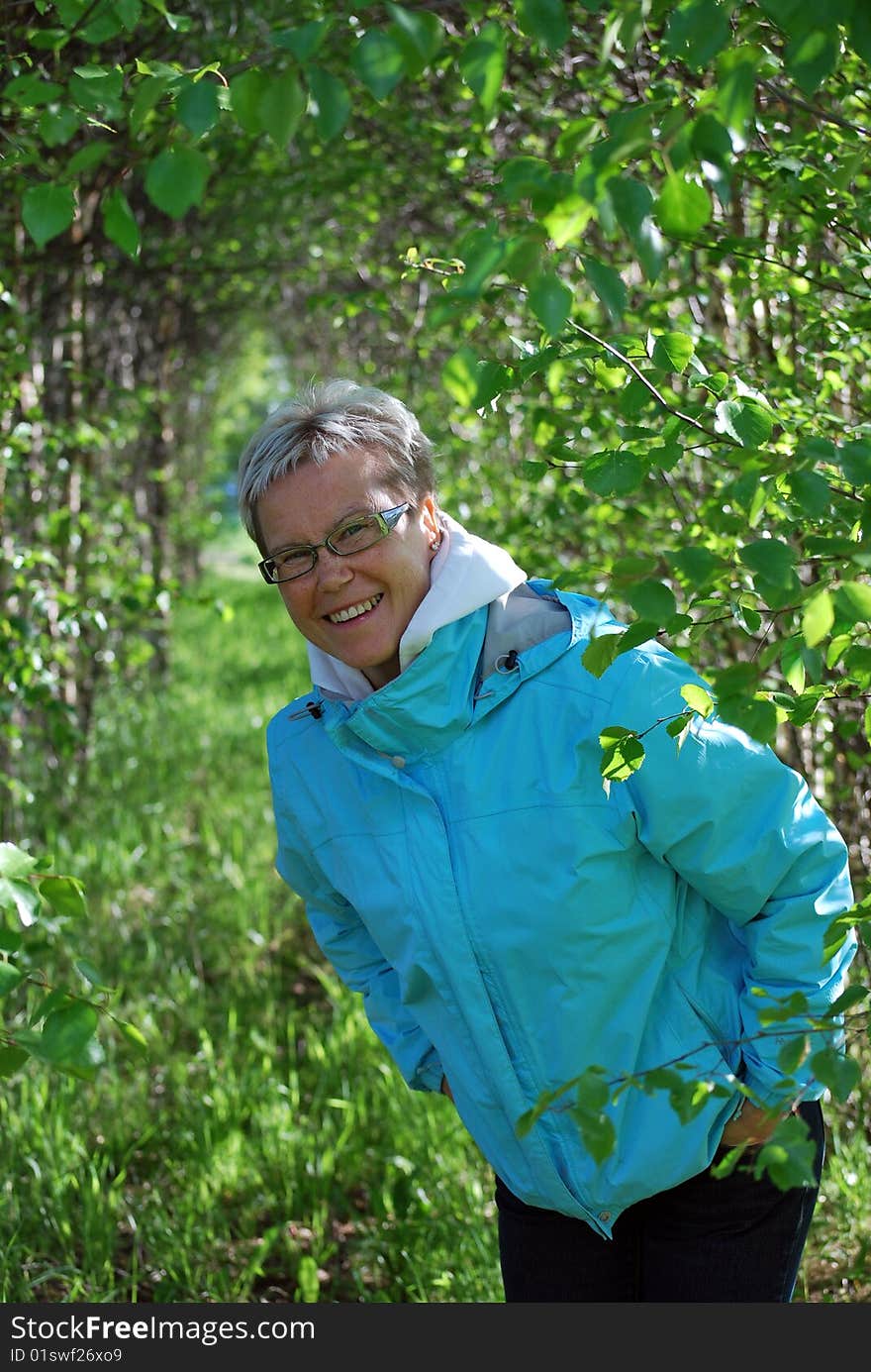 Woman peeking around a birch tree. Woman peeking around a birch tree