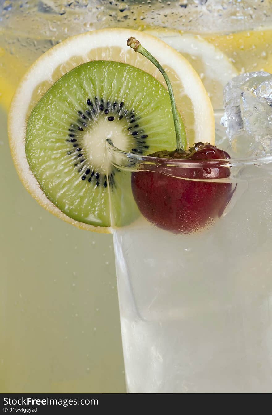 Red cherry, kiwi and lemon slice garnish on glass of ice cold lemonade. Red cherry, kiwi and lemon slice garnish on glass of ice cold lemonade