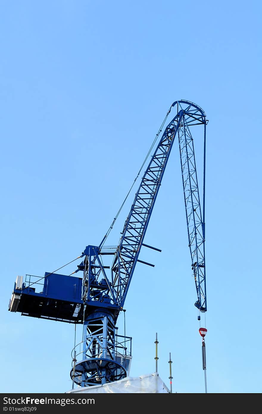 Blue construction crane with blue sky on background