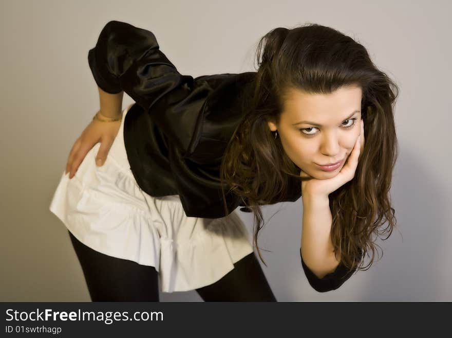 Beautiful young adult girl in black elegant dress posing in studio