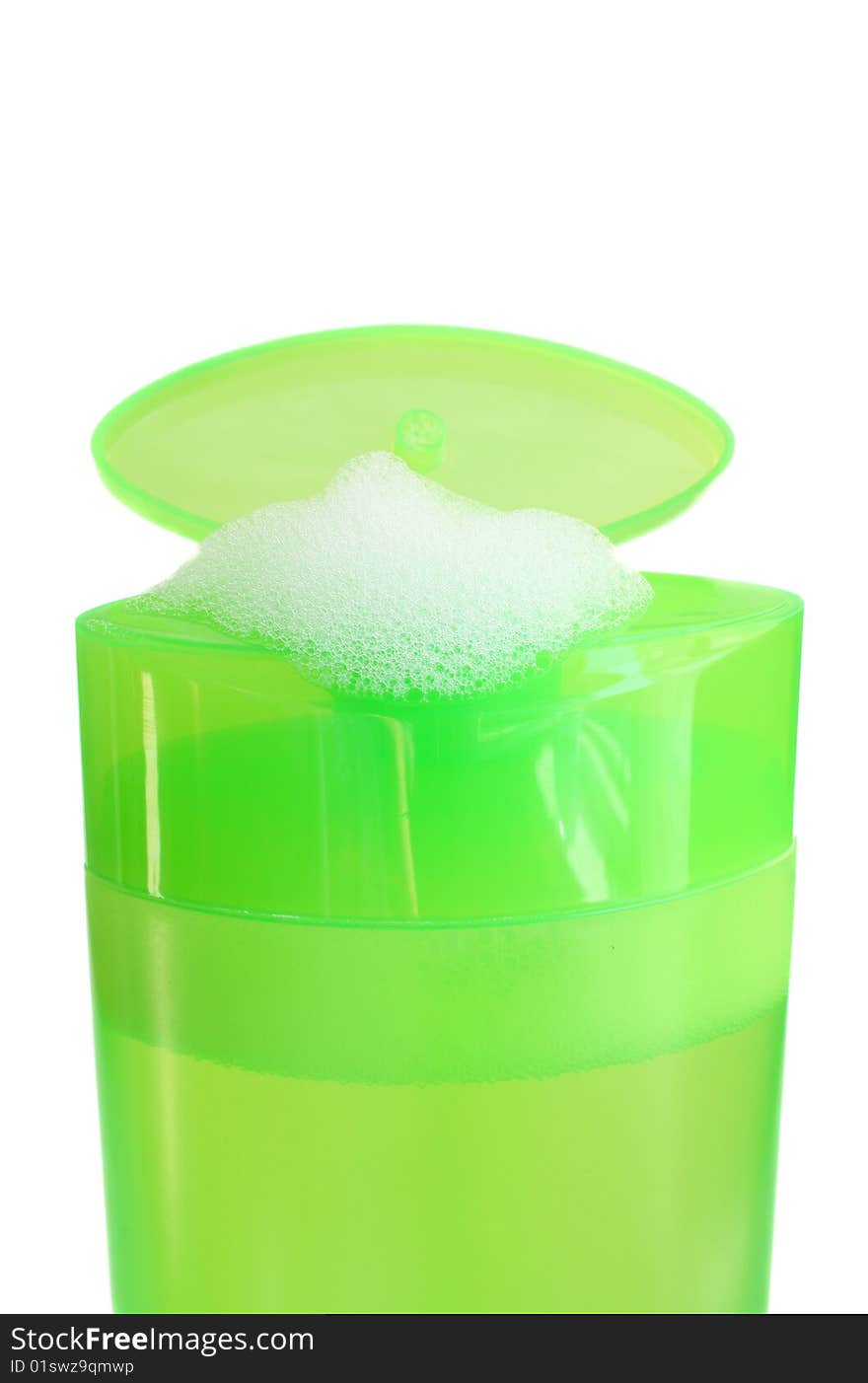 Green bottle shampoo with foam on a white background, is isolated.