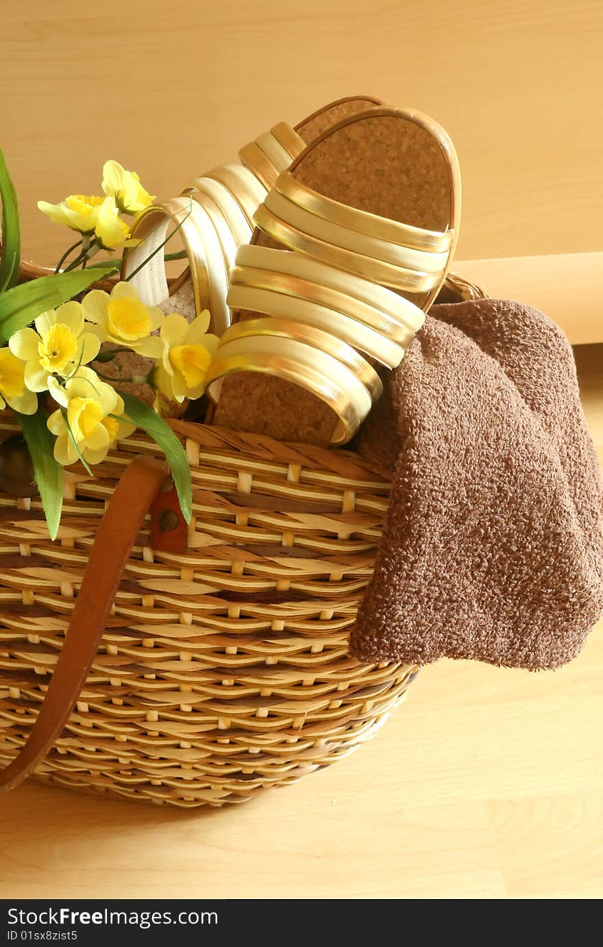 Beach bag with female summer footwear, towel and yellow flowers