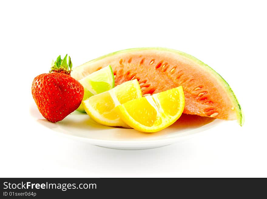 Lemon, lime and orange wedges with a red ripe strawberry and slice of juicy watermelon on a plate with a white background. Lemon, lime and orange wedges with a red ripe strawberry and slice of juicy watermelon on a plate with a white background