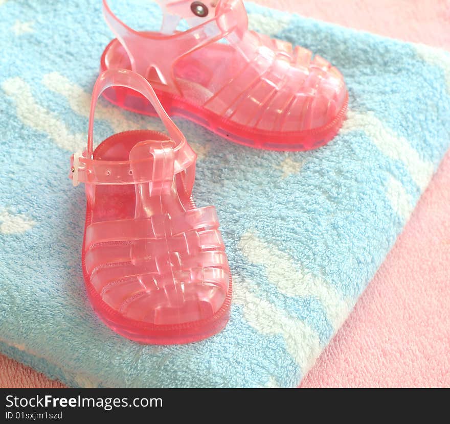 Pink children s footwear on blue  towels