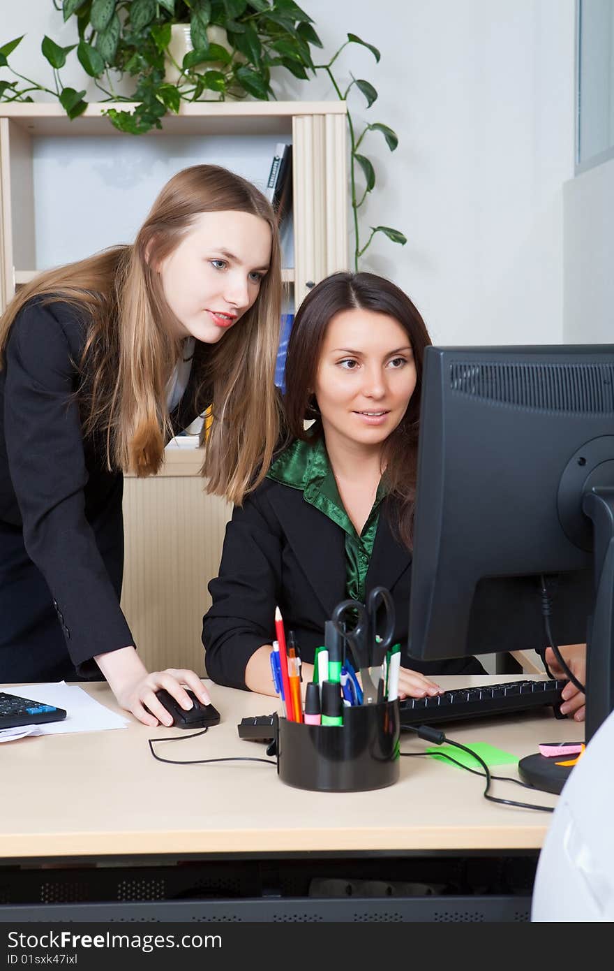 Two business women look at the screen. Two business women look at the screen