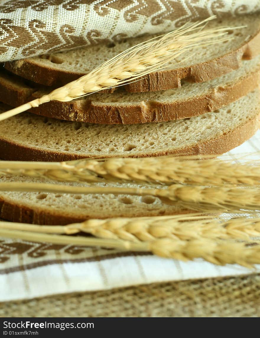 Wheat ears and bread with kitchen towel