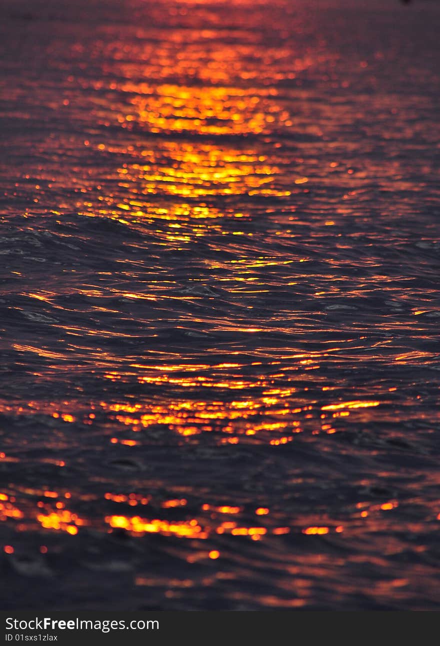 Colorful ripples as sun sets over water. Colorful ripples as sun sets over water