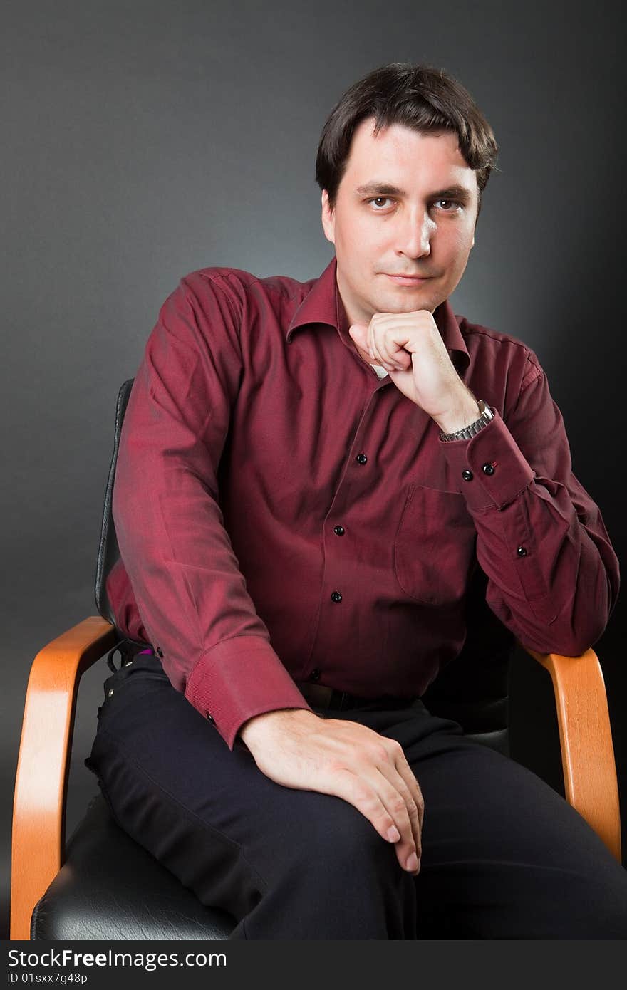 Man in a red shirt against a dark background. Man in a red shirt against a dark background