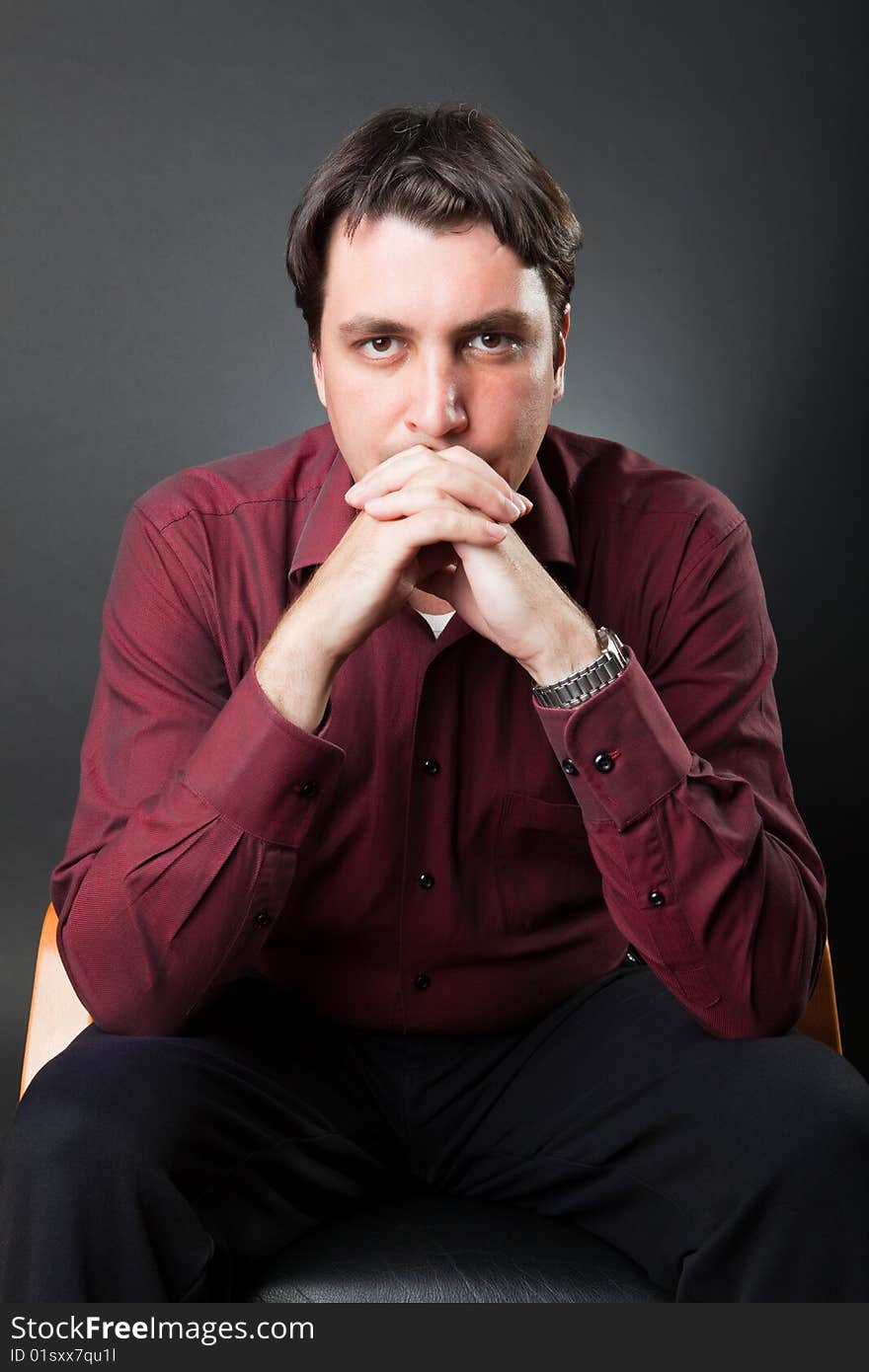 Man in a red shirt against a dark background. Man in a red shirt against a dark background