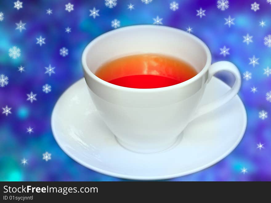 Big cup of tea in front of blue background with snowflakes allover. Big cup of tea in front of blue background with snowflakes allover