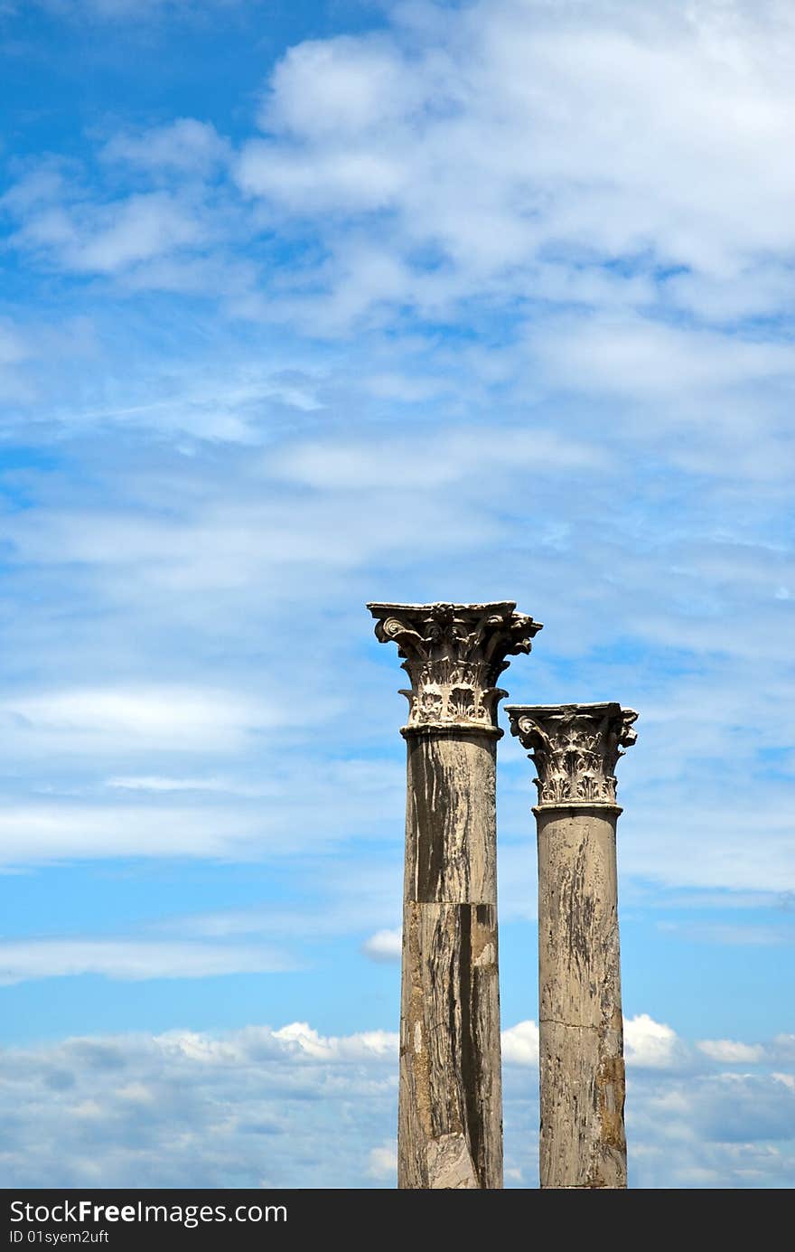 Two old marble columns against the blue sky