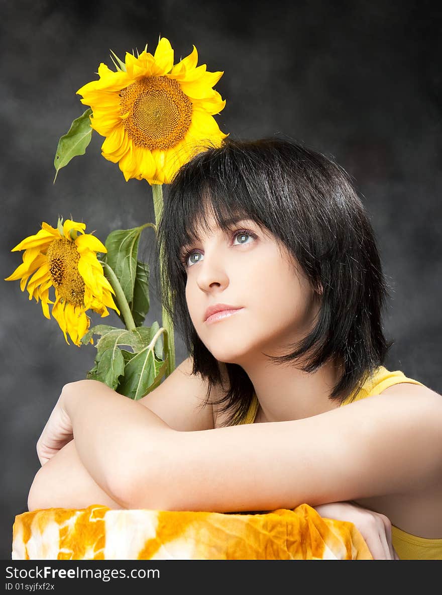 Portrait of a beautiful girl with sunflowers, studio shot