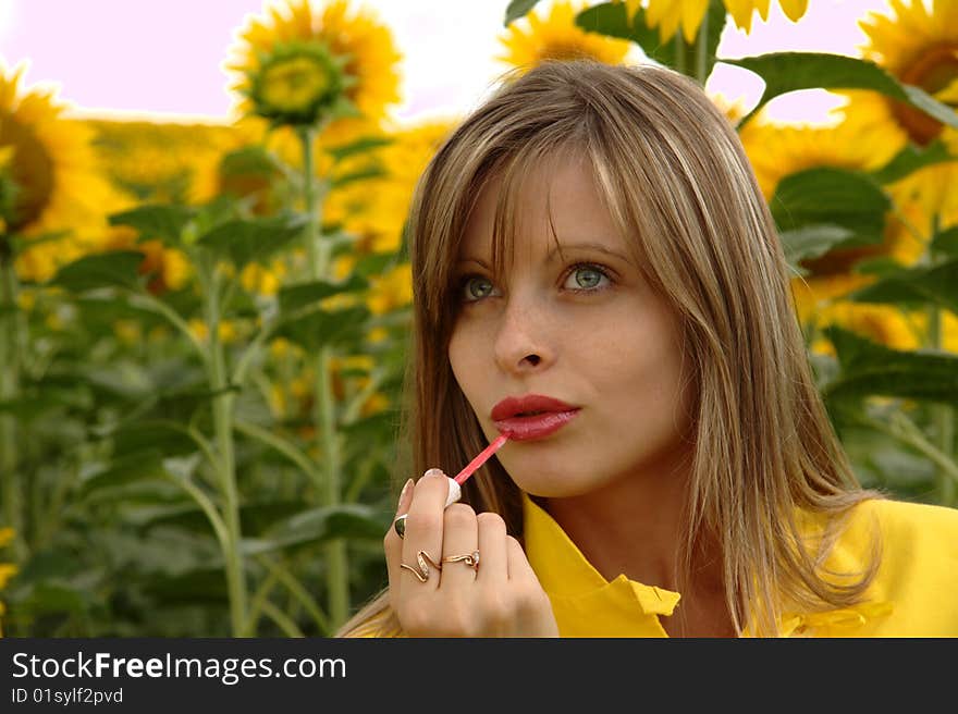 Portrait Of Beauty Young Woman Applying Lipstick