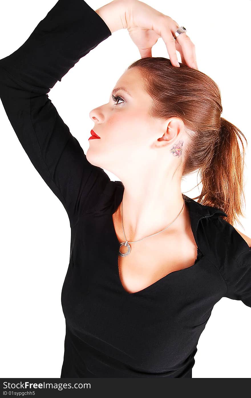 Young light red haired woman in an black dress standing in the studio for white background, has her right hand on her head and thinking. Young light red haired woman in an black dress standing in the studio for white background, has her right hand on her head and thinking.