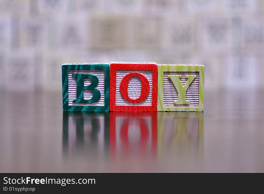 The word boy spelled out in wooden letter blocks. The word boy spelled out in wooden letter blocks