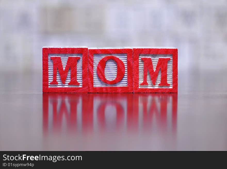 The word mom spelled out in wooden letter blocks