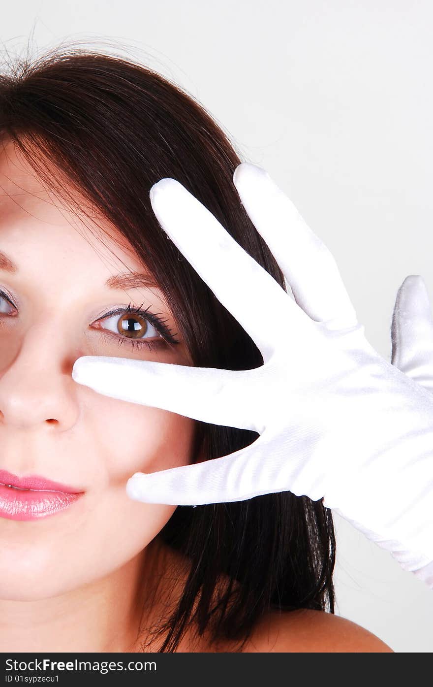 The halve face of a beautiful woman with her finger on the face in an
white clove, for light gray background. The halve face of a beautiful woman with her finger on the face in an
white clove, for light gray background.