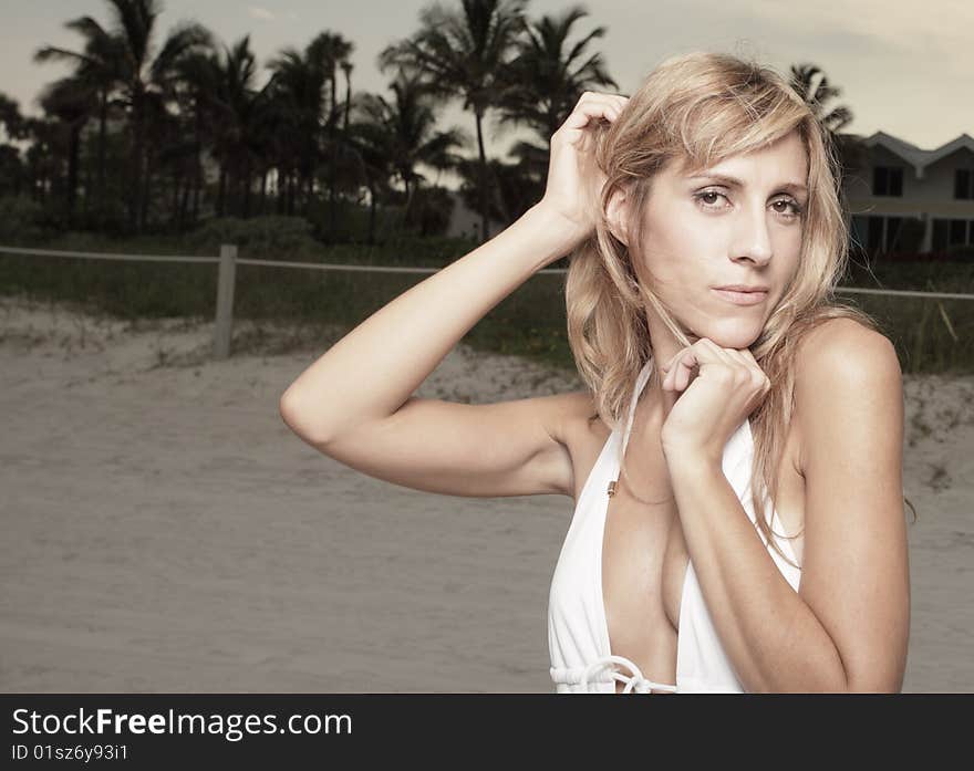 Beautiful young woman posing on the beach in a stylish bathing suit. Beautiful young woman posing on the beach in a stylish bathing suit