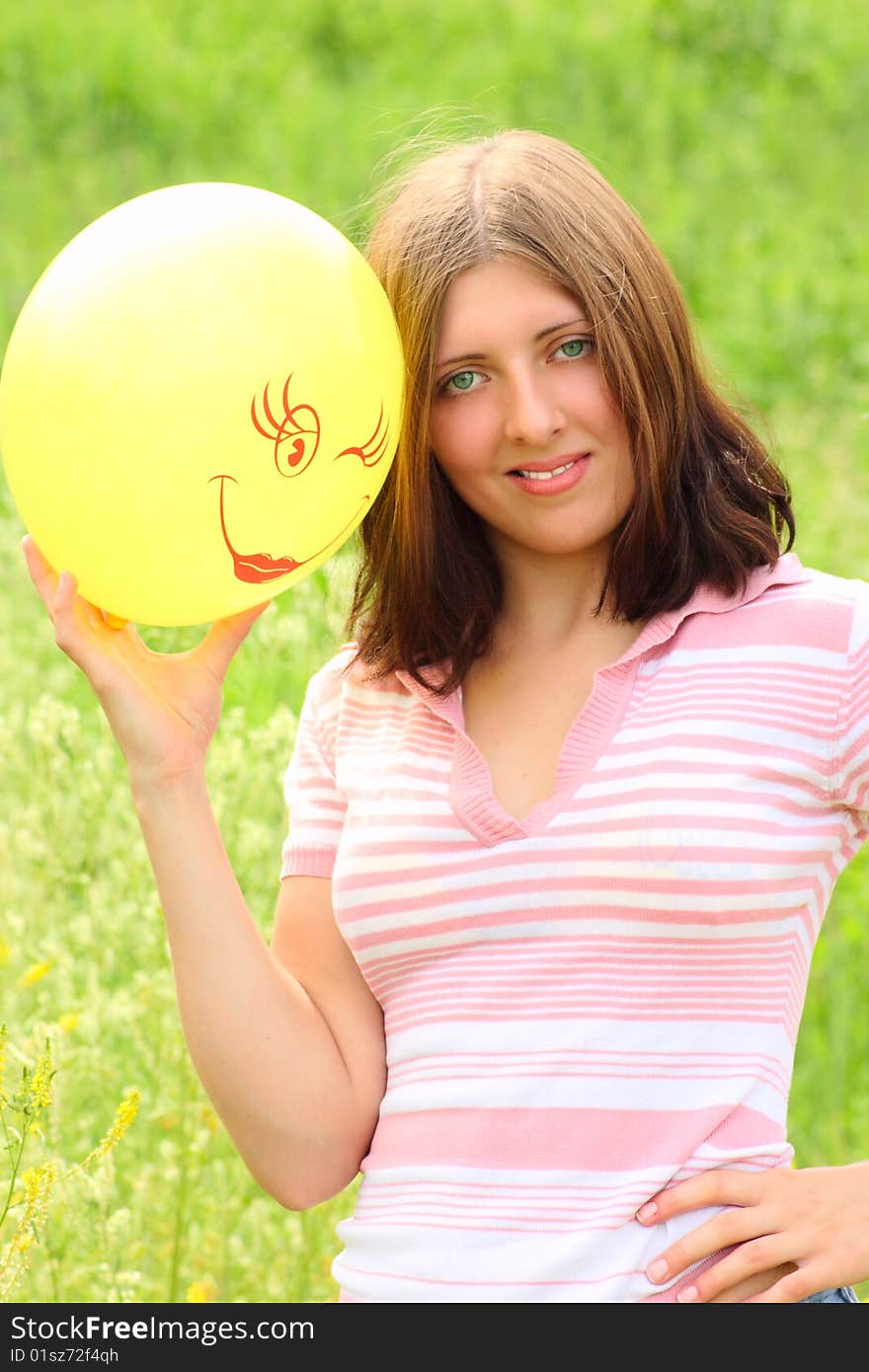 The girl with a balloon on a summer meadow. The girl with a balloon on a summer meadow