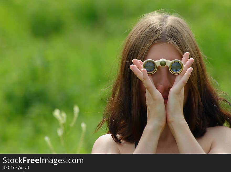 The girl on a summer meadow with opera glasses. The girl on a summer meadow with opera glasses