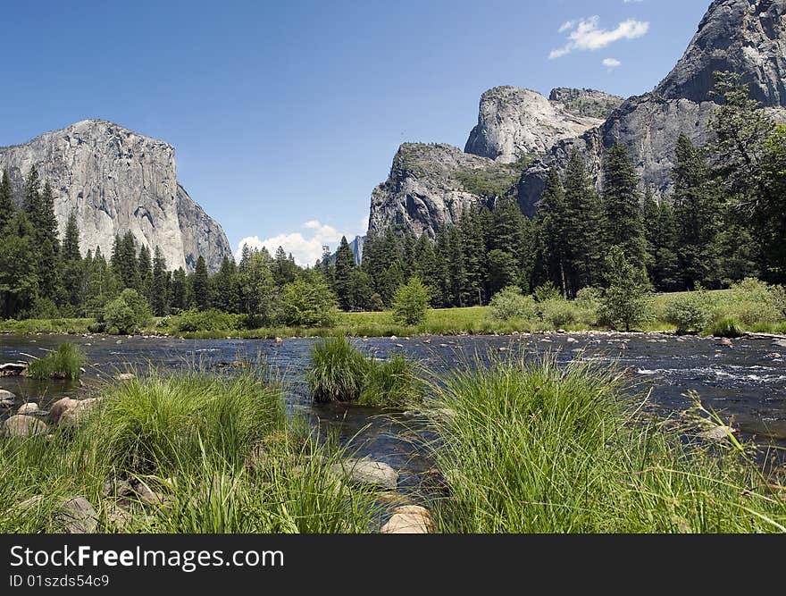 View of Yosemite Valley with a River in the foreground and Mountains in the background. View of Yosemite Valley with a River in the foreground and Mountains in the background