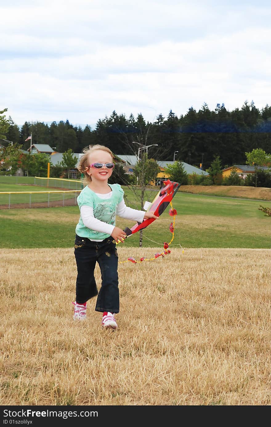 Smiling Kid Playing With Kite In The Park.