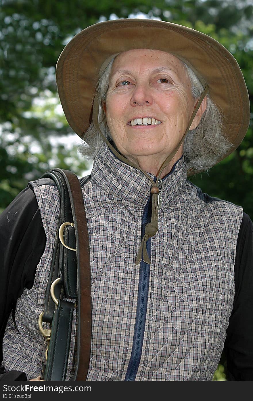 Color Photograph of a senior woman getting ready to saddle up her horse. Color Photograph of a senior woman getting ready to saddle up her horse.