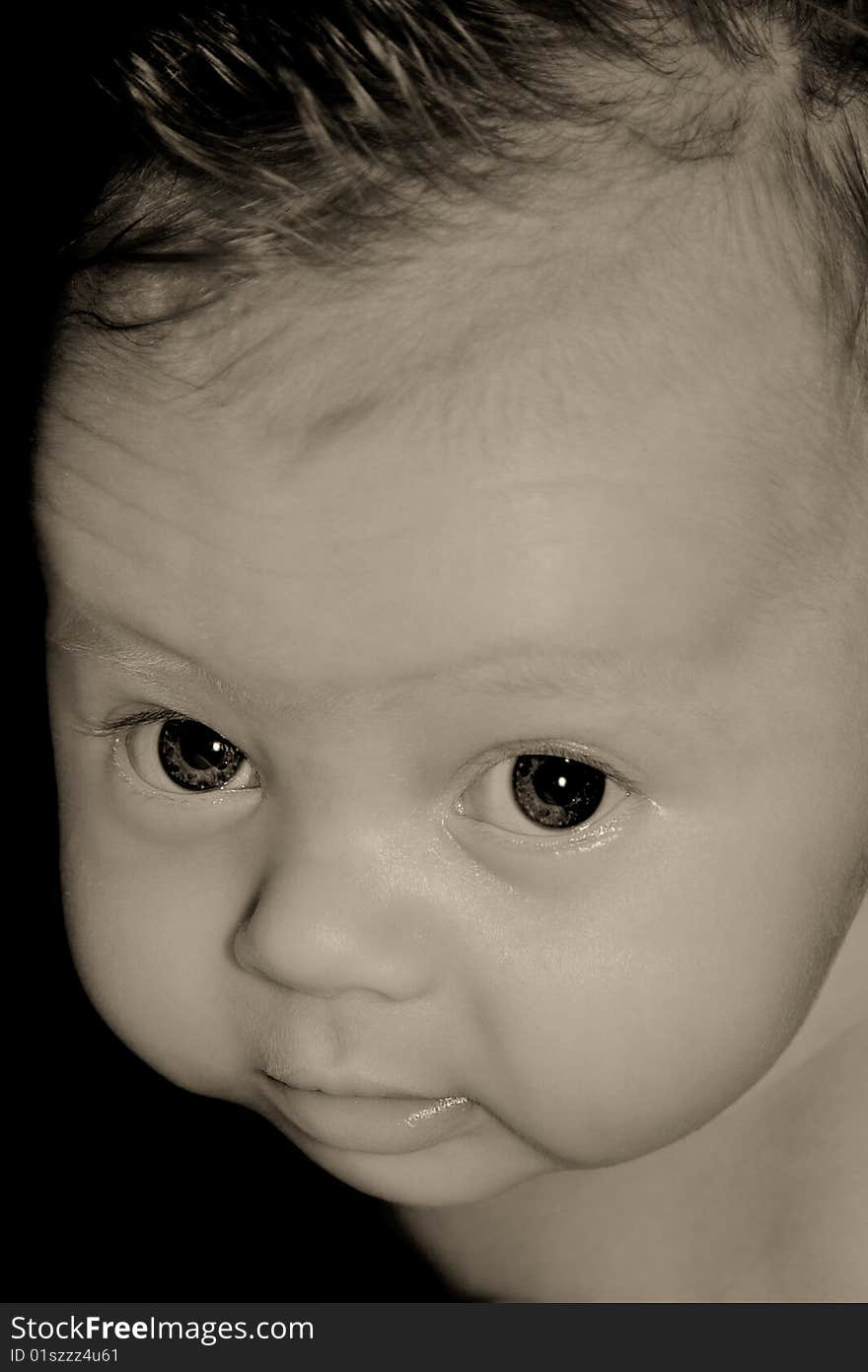 Close-up monochrome toned portrait of serious baby.