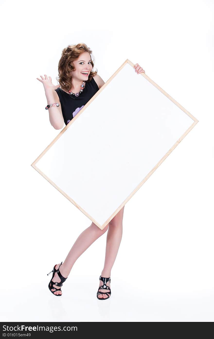 Young emotional woman on isolated background holding a blank board