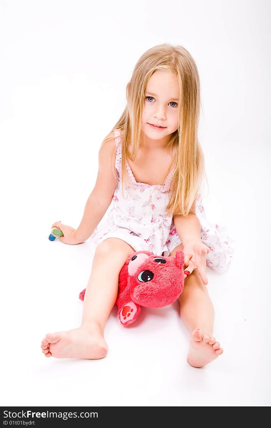 Beautiful little girl with long blonde hair and red bear