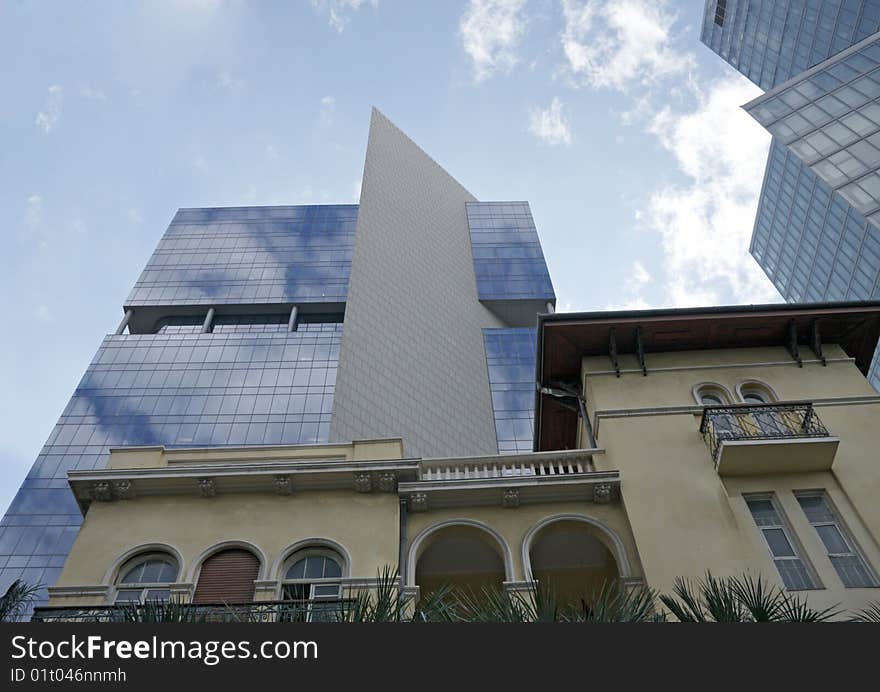 Old and new building with sky reflection