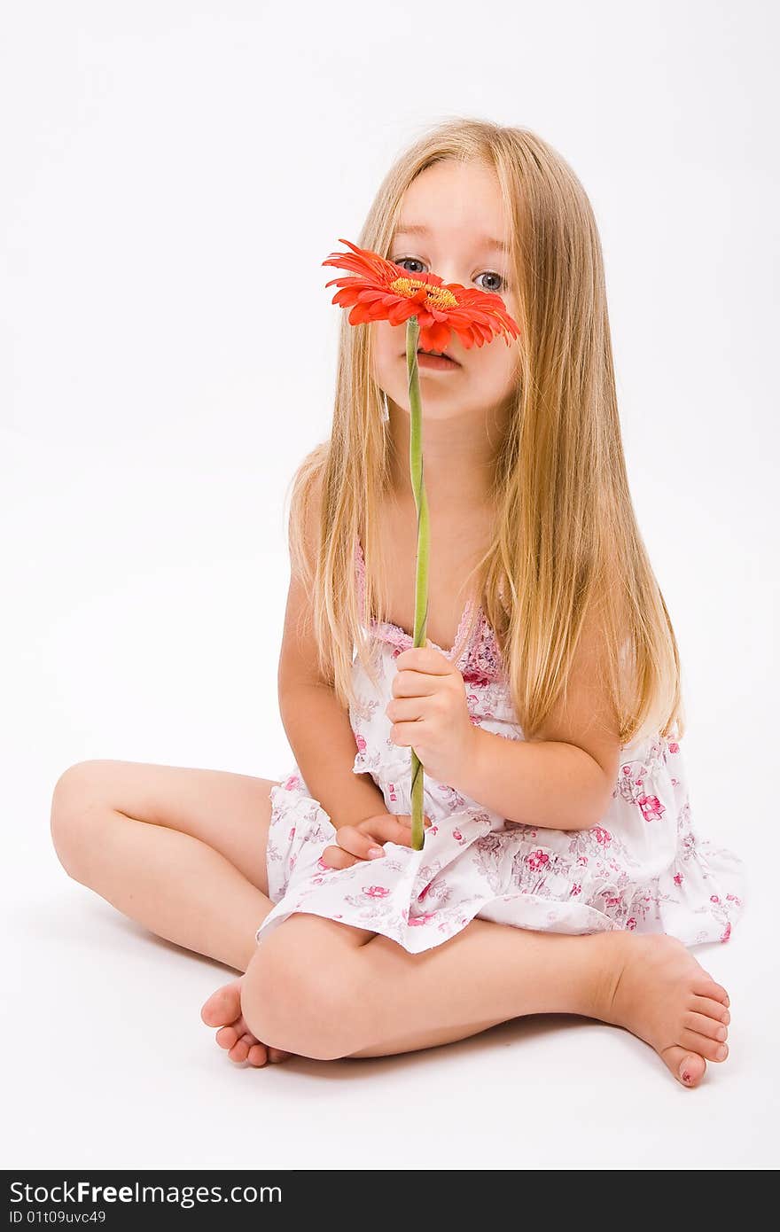 Beautiful little girl with long blonde hairand red flower