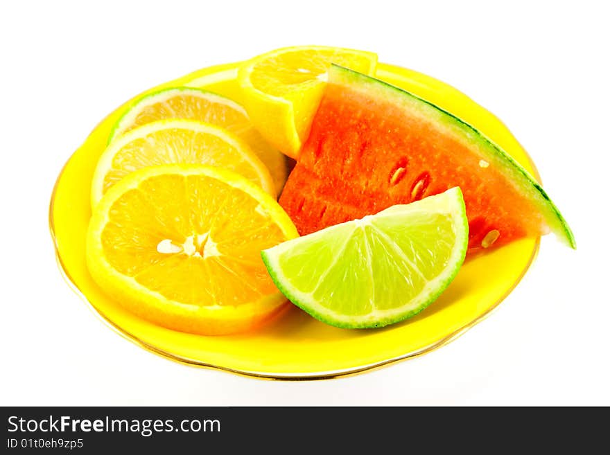 Lemon, lime and orange segments on a fancy yellow plate with juicy watermelon on a white background. Lemon, lime and orange segments on a fancy yellow plate with juicy watermelon on a white background