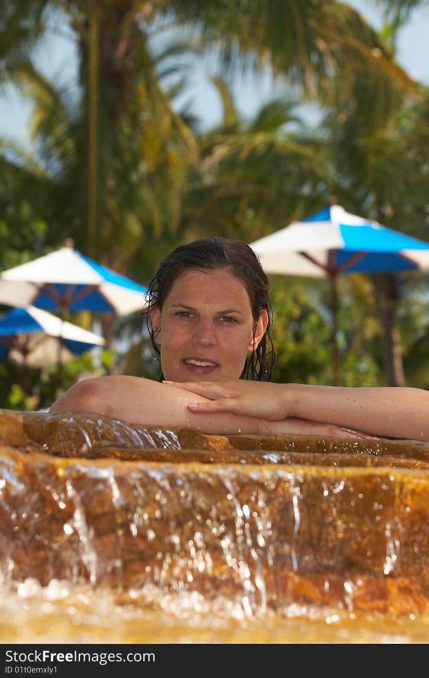 Young woman in a beautiful pool with palms in the background. Young woman in a beautiful pool with palms in the background.