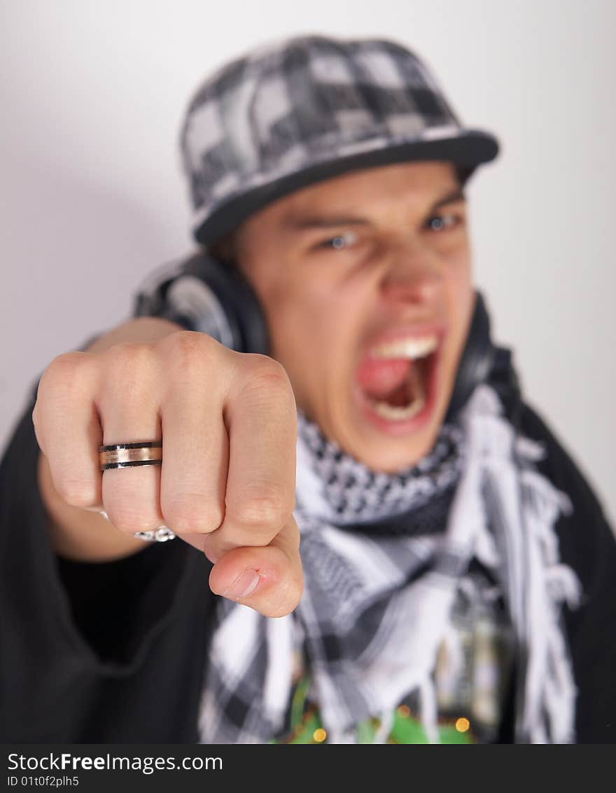 A young DJ is pointing at the camera and screaming. The focus is on his fist! Isolated over white. A young DJ is pointing at the camera and screaming. The focus is on his fist! Isolated over white.