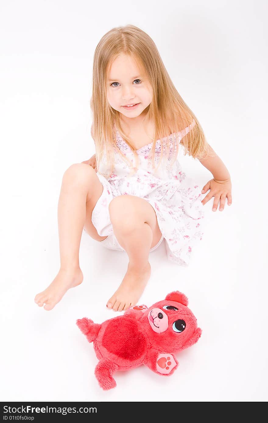 Beautiful little girl with long blonde hair and red bear