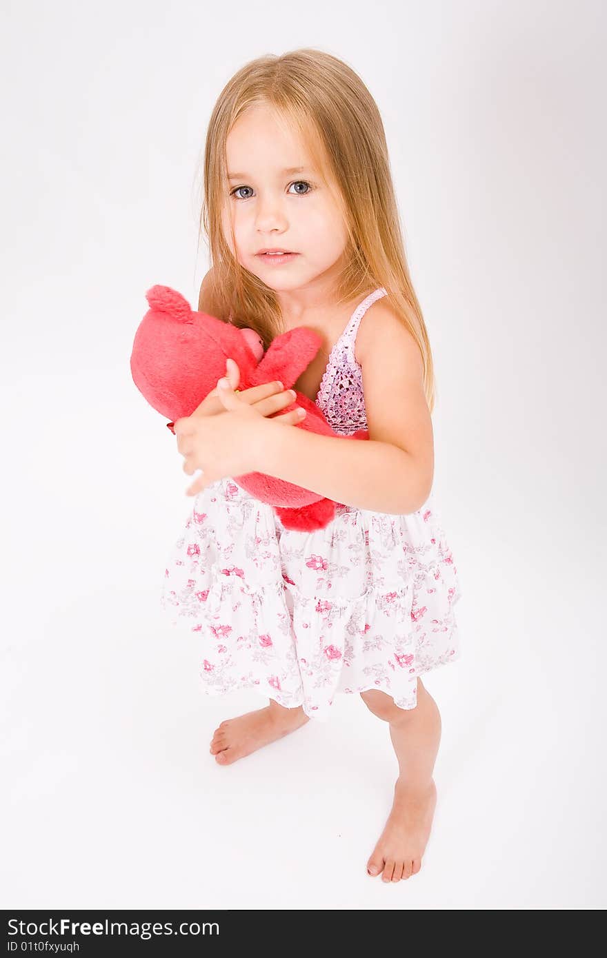 Beautiful little girl with long blonde hair and red bear