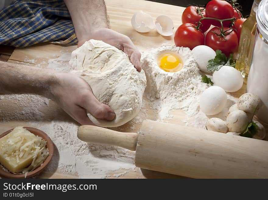 Overhead shot of a man kneading a dough on a wooden  table. Overhead shot of a man kneading a dough on a wooden  table