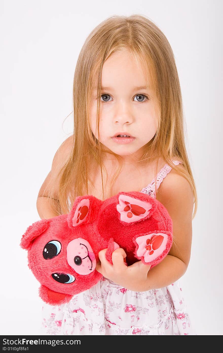 Beautiful little girl with long blonde hair and red bear