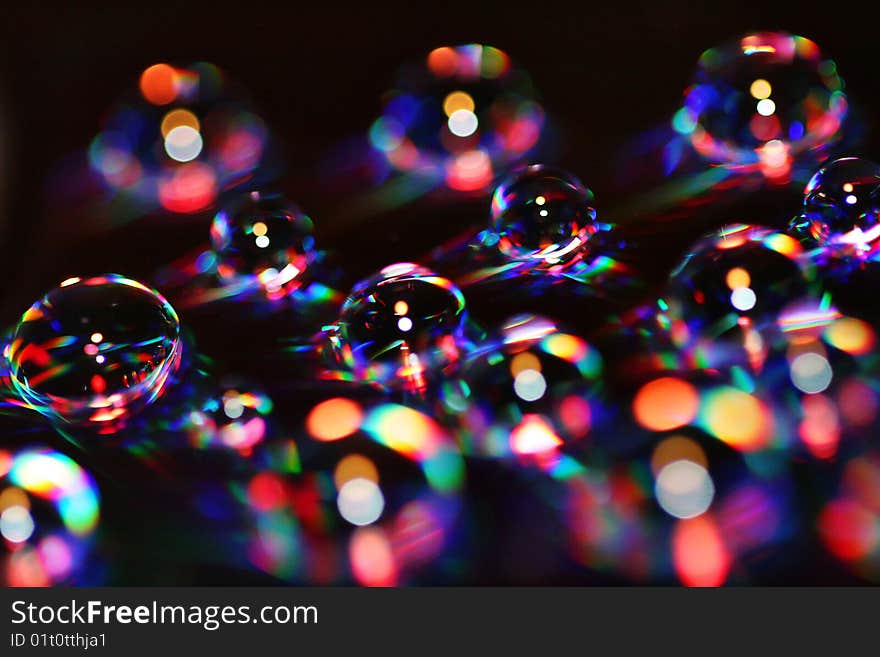 Water drops over a DVD become colorful bubbles