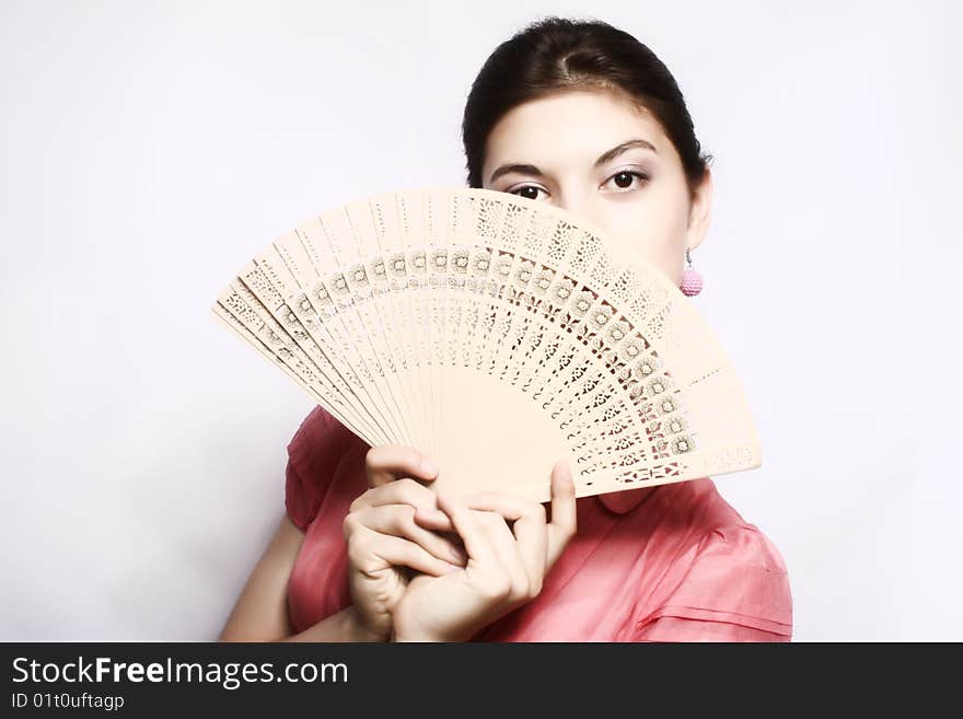 Portrait of the girl in pink to a blouse and a fan in a hand. Portrait of the girl in pink to a blouse and a fan in a hand.