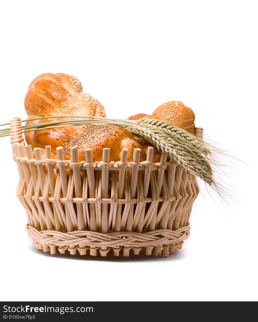 Fresh baked rolls in a basket on white