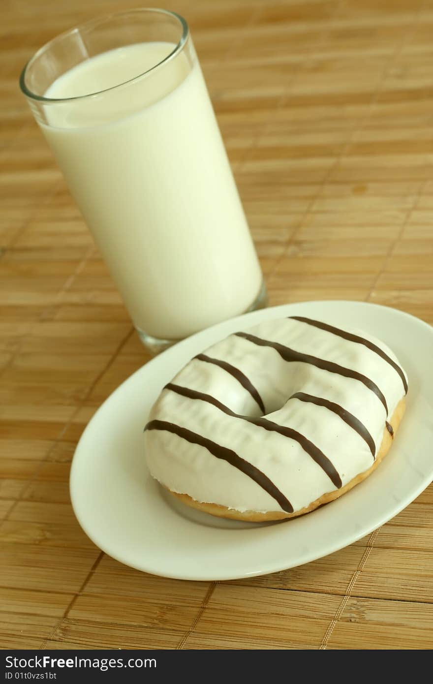 Breakfast. Glass of milk and donut.