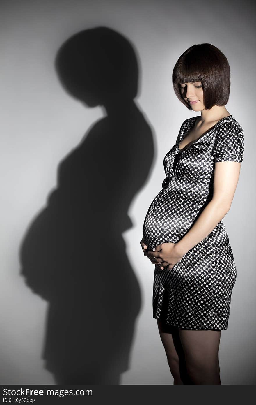 Silhouette of woman eight months pregnant.