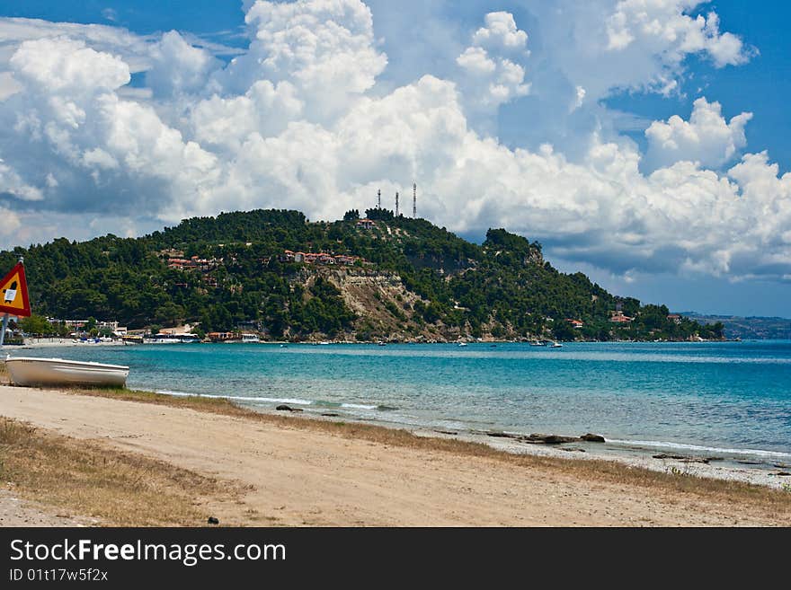 Marine landscape. Greece, Kassandra. Blue sea and sky, small towns with red roofs.